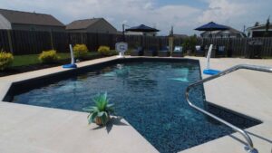 An inground fiberglass pool with an asymmetrical design