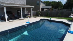An inground pool shines in the afternoon sunlight.