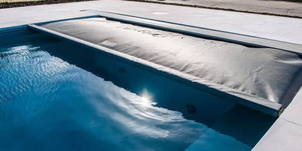 Modern fiberglass swimming pool installed in a residential backyard with surrounding patio and landscaping | Ultimate Guide to Fiberglass Pools